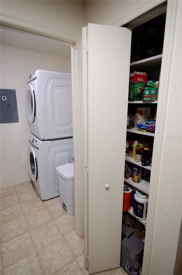 3705 SW 27th St Unit 223, Gainesville, FL 32608 - washroom with stacked washing machine and dryer, electric panel, and light tile patterned flooring
