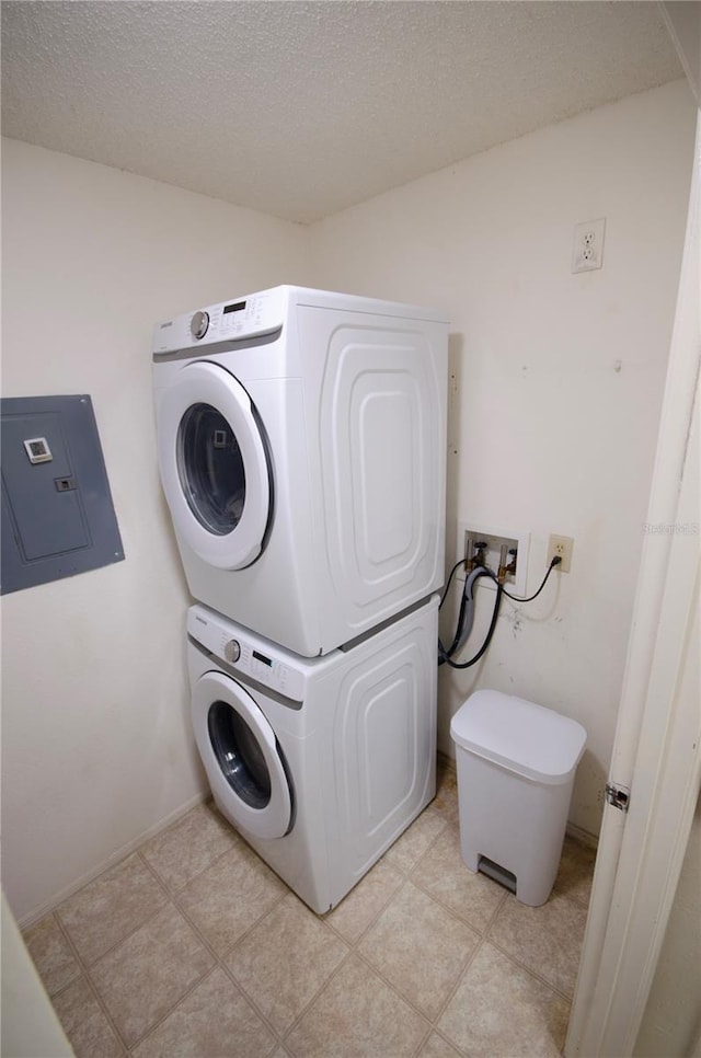3705 SW 27th St Unit 223, Gainesville, FL 32608 - washroom featuring estacked washer and dryer, electric panel, and a textured ceiling
