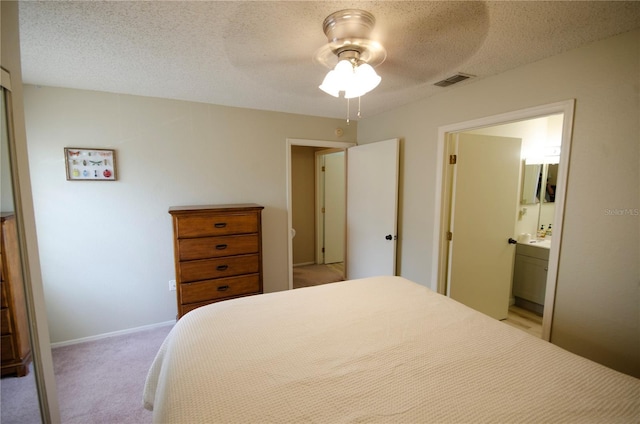 3705 SW 27th St Unit 223, Gainesville, FL 32608 - bedroom featuring light carpet, connected bathroom, a textured ceiling, and a ceiling fan