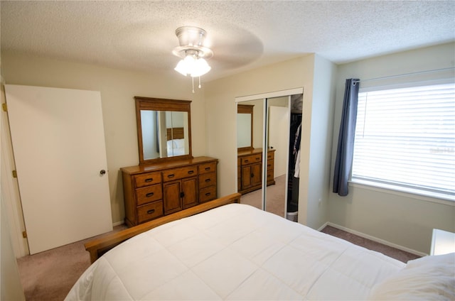 3705 SW 27th St Unit 223, Gainesville, FL 32608 - bedroom featuring carpet flooring, a closet, a textured ceiling, and a ceiling fan