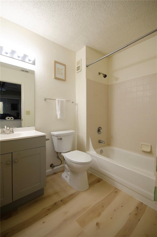 3705 SW 27th St Unit 223, Gainesville, FL 32608 - bathroom featuring wood finished floors, vanity, shower / washtub combination, and a textured ceiling