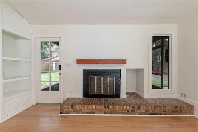 1745 NW 42nd Ave, Gainesville, FL 32605 - unfurnished living room with a fireplace, wood finished floors, and built in features