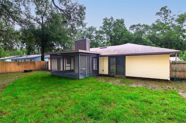 1745 NW 42nd Ave, Gainesville, FL 32605 - back of house featuring a sunroom, a chimney, and a fenced backyard