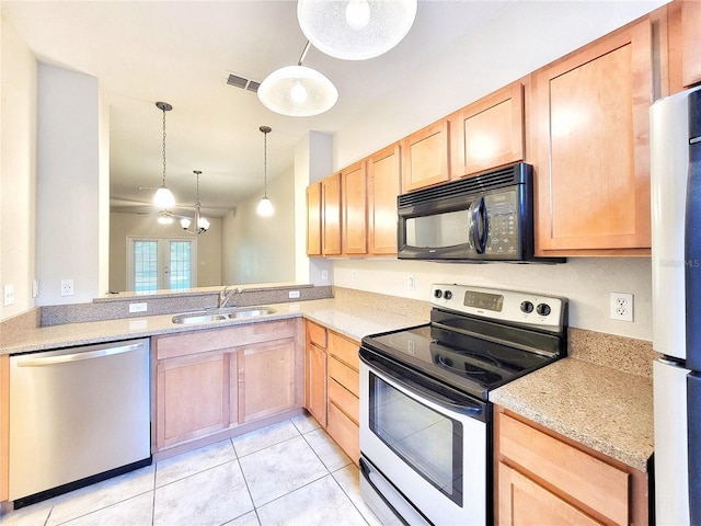 2508 SW 35th Pl Unit L-70, Gainesville, FL 32608 - kitchen with appliances with stainless steel finishes, light brown cabinets, a chandelier, light tile patterned floors, and pendant lighting