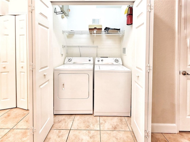 2508 SW 35th Pl Unit L-70, Gainesville, FL 32608 - washroom featuring washer and dryer and light tile patterned floors