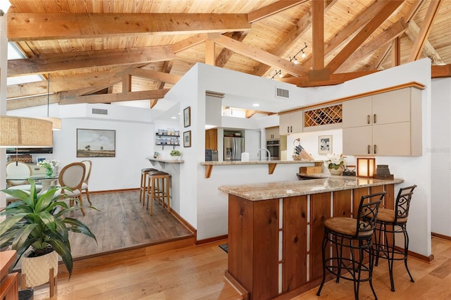 6501 NW 16th Pl, Gainesville, FL 32605 - kitchen with appliances with stainless steel finishes, a wooden ceiling with exposed beams, a peninsula, high vaulted ceiling, and a breakfast bar