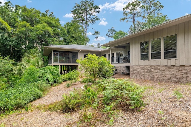6501 NW 16th Pl, Gainesville, FL 32605 - view of front facade with a sunroom, stone siding, and board and batten siding