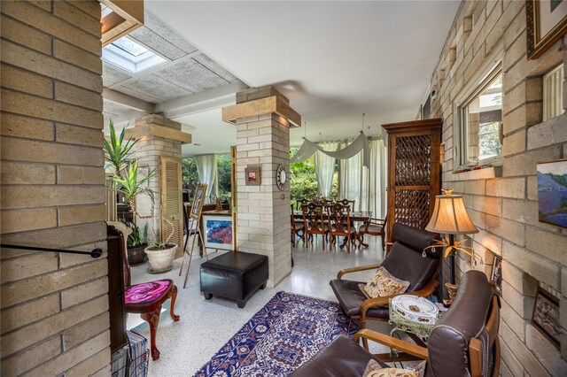 2010 NW 32nd Ter, Gainesville, FL 32605 - living area featuring decorative columns, speckle patterned floor, and a skylight
