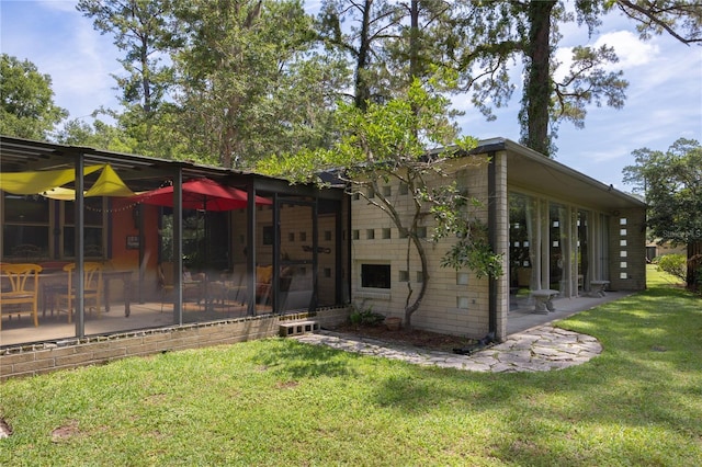 2010 NW 32nd Ter, Gainesville, FL 32605 - rear view of house with a yard, a sunroom, and a patio area