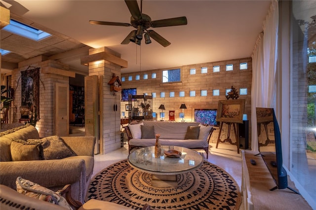 2010 NW 32nd Ter, Gainesville, FL 32605 - living room featuring a skylight, a ceiling fan, brick wall, and decorative columns