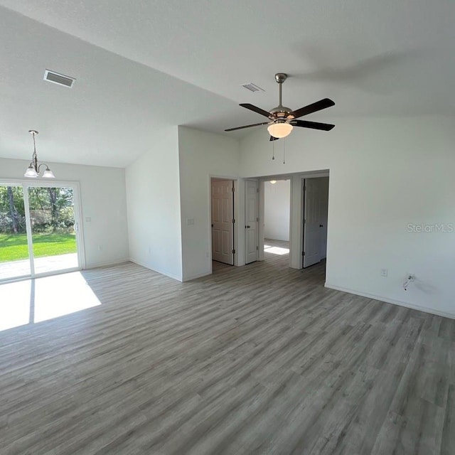 15433 SW 47th Avenue Rd, Ocala, FL 34473 - unfurnished living room featuring wood finished floors, lofted ceiling, ceiling fan, and a chandelier