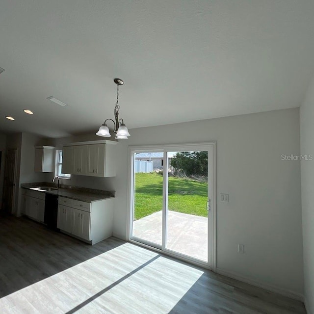 15433 SW 47th Avenue Rd, Ocala, FL 34473 - kitchen with wood finished floors, dishwasher, a chandelier, white cabinets, and plenty of natural light
