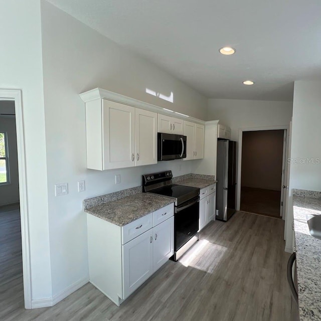 15433 SW 47th Avenue Rd, Ocala, FL 34473 - kitchen featuring appliances with stainless steel finishes, light wood-style floors, white cabinets, recessed lighting, and light stone counters