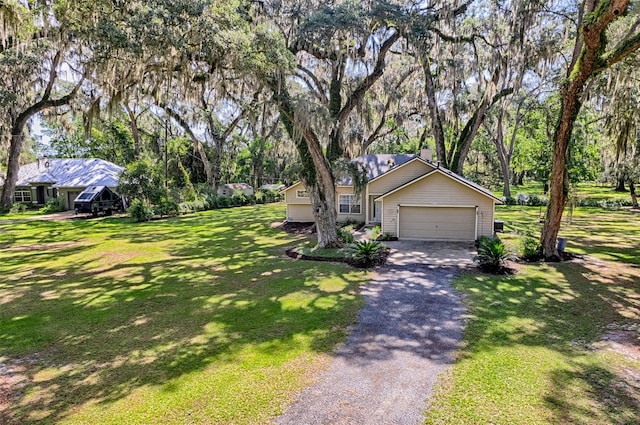 6505 SW 135th Pl, Archer, FL 32618 - view of front of property with asphalt driveway, a front yard, an attached garage, and view of wooded area