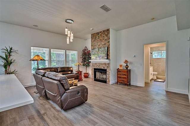 6505 SW 135th Pl, Archer, FL 32618 - living room featuring a stone fireplace, wood finished floors, and a chandelier