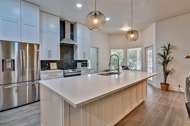 6505 SW 135th Pl, Archer, FL 32618 - kitchen with stainless steel appliances, wall chimney exhaust hood, light wood-type flooring, backsplash, and light countertops