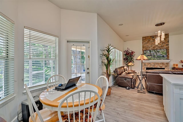 6505 SW 135th Pl, Archer, FL 32618 - dining space featuring light wood finished floors, healthy amount of natural light, a chandelier, and a stone fireplace