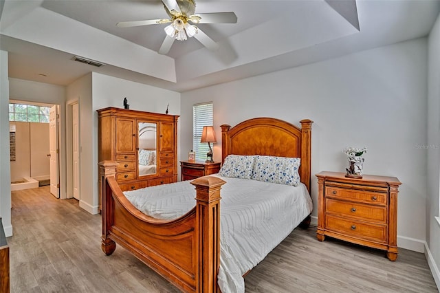 6505 SW 135th Pl, Archer, FL 32618 - bedroom featuring a tray ceiling, light wood-type flooring, and ceiling fan