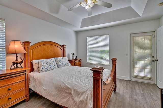 6505 SW 135th Pl, Archer, FL 32618 - bedroom featuring a raised ceiling, light wood finished floors, a ceiling fan, and access to exterior