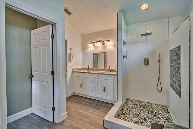 6505 SW 135th Pl, Archer, FL 32618 - bathroom featuring a tile shower, double vanity, wood finished floors, and recessed lighting