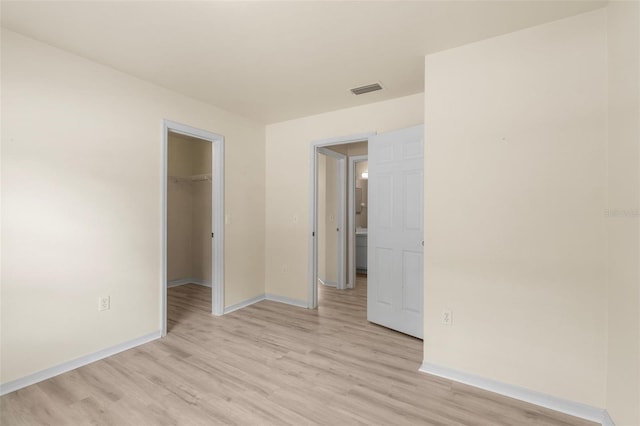 3846 NW 62nd Pl, Gainesville, FL 32653 - unfurnished bedroom featuring light wood-style floors, a spacious closet, and a closet