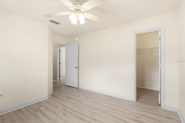 3846 NW 62nd Pl, Gainesville, FL 32653 - unfurnished bedroom with light wood-type flooring, a walk in closet, a closet, and a ceiling fan