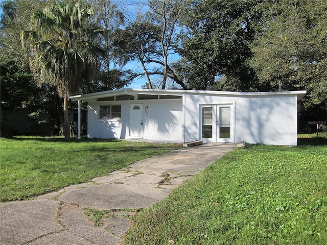 2904 NE 11th Ter, Gainesville, FL 32609 - mid-century home featuring a front lawn, french doors, and driveway