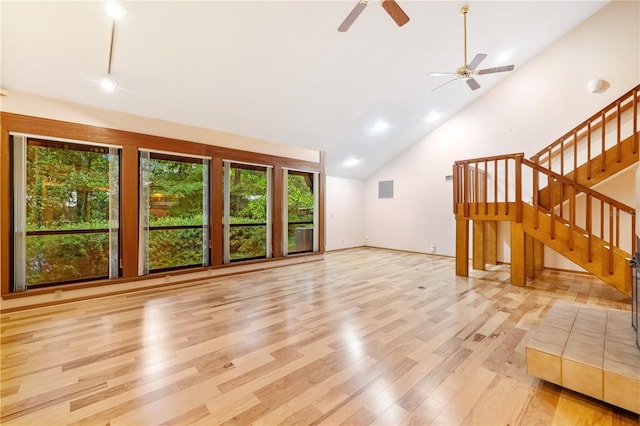1225 NW 23rd Ter, Gainesville, FL 32605 - unfurnished living room with light wood-style floors, ceiling fan, stairway, and high vaulted ceiling
