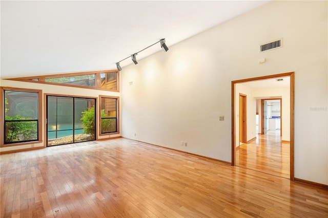 1225 NW 23rd Ter, Gainesville, FL 32605 - spare room featuring high vaulted ceiling, light wood finished floors, and track lighting