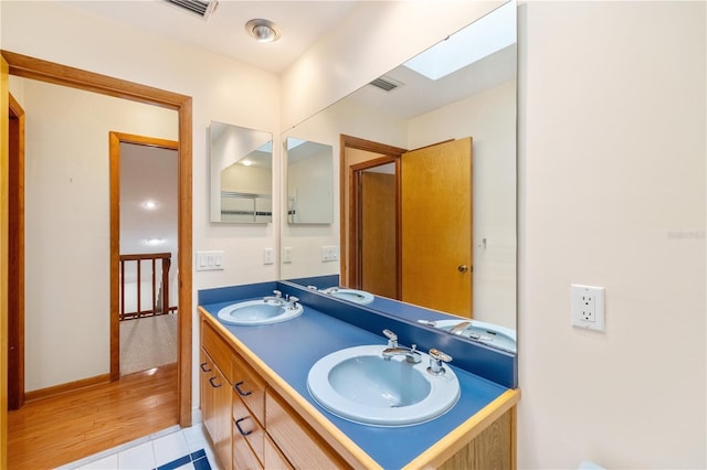 1225 NW 23rd Ter, Gainesville, FL 32605 - full bath featuring a skylight, double vanity, and tile patterned flooring