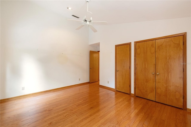 1225 NW 23rd Ter, Gainesville, FL 32605 - unfurnished bedroom featuring multiple closets, light wood finished floors, ceiling fan, and high vaulted ceiling
