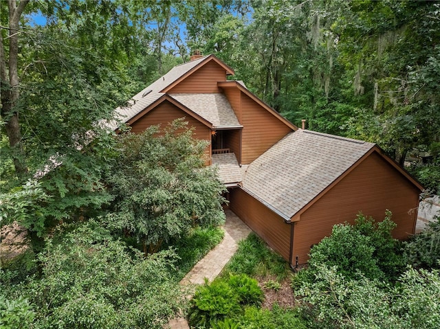 1225 NW 23rd Ter, Gainesville, FL 32605 - view of property exterior with a shingled roof and a chimney