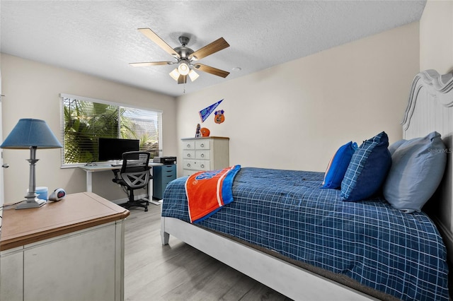 1700 SW 16th Ct Unit E9, Gainesville, FL 32608 - bedroom with light wood-style flooring, a textured ceiling, ceiling fan, and an office area