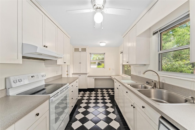 3857 SW 4th Pl, Gainesville, FL 32607 - kitchen with white electric range oven, under cabinet range hood, dark flooring, and white cabinets