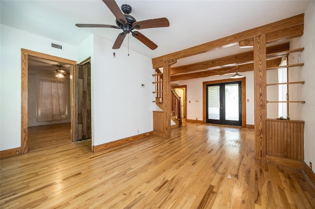 407 NW 8th St, Gainesville, FL 32601 - unfurnished living room featuring stairway, light wood-style floors, ceiling fan, french doors, and beam ceiling