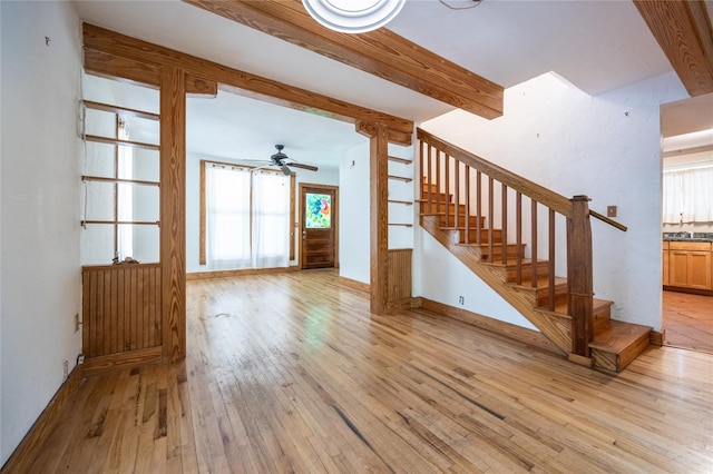 407 NW 8th St, Gainesville, FL 32601 - unfurnished living room with stairway, light wood-type flooring, a ceiling fan, and beam ceiling