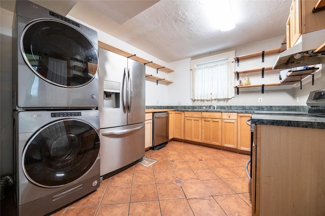 407 NW 8th St, Gainesville, FL 32601 - kitchen with open shelves, appliances with stainless steel finishes, stacked washer / drying machine, dark countertops, and a textured ceiling