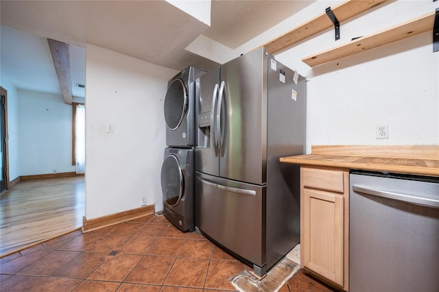 407 NW 8th St, Gainesville, FL 32601 - kitchen featuring appliances with stainless steel finishes, stacked washer / dryer, butcher block countertops, dark tile patterned flooring, and light brown cabinets