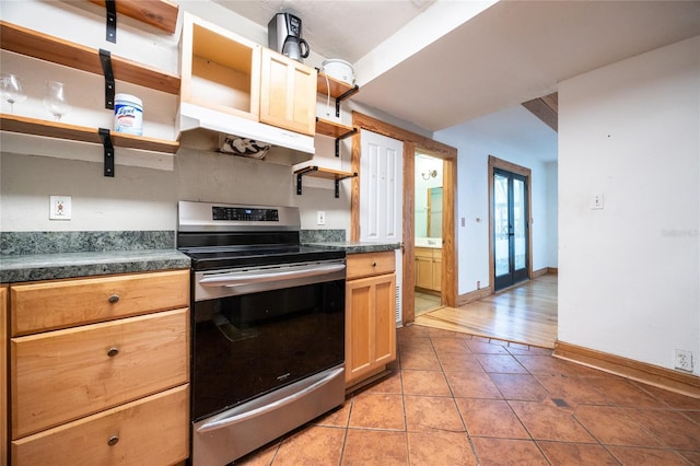 407 NW 8th St, Gainesville, FL 32601 - kitchen featuring electric range, open shelves, under cabinet range hood, dark countertops, and light tile patterned flooring