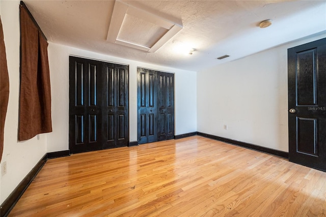 407 NW 8th St, Gainesville, FL 32601 - unfurnished bedroom featuring attic access, two closets, and wood finished floors