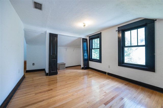 407 NW 8th St, Gainesville, FL 32601 - unfurnished bedroom with light wood-style flooring, vaulted ceiling, and a closet