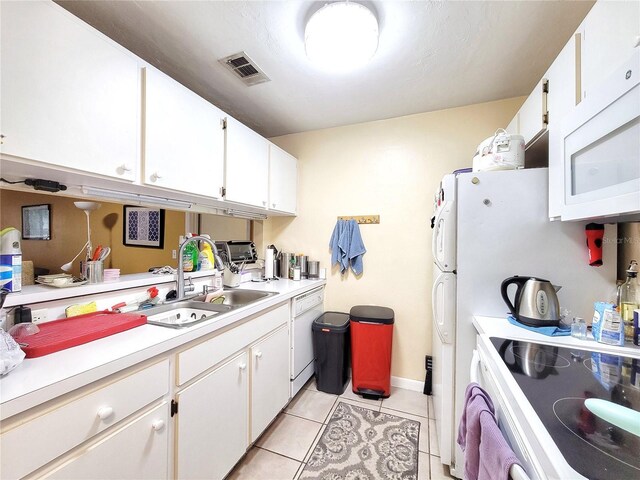 4000 SW 23rd St Unit 2-104, Gainesville, FL 32608 - kitchen featuring white appliances, light tile patterned floors, light countertops, and white cabinets