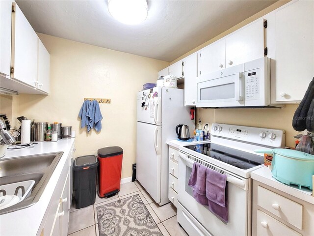4000 SW 23rd St Unit 2-104, Gainesville, FL 32608 - kitchen with white appliances, light countertops, white cabinetry, and light tile patterned flooring
