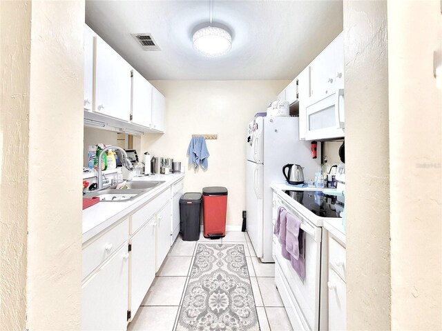 4000 SW 23rd St Unit 2-104, Gainesville, FL 32608 - kitchen with white appliances, light countertops, light tile patterned floors, and white cabinets