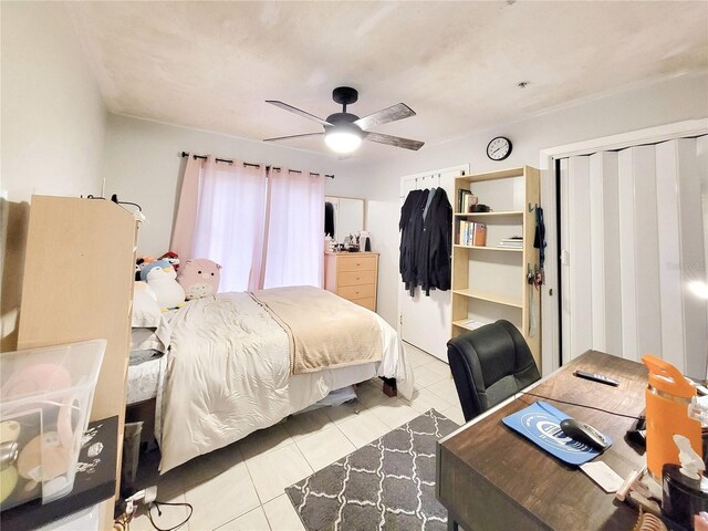 4000 SW 23rd St Unit 2-104, Gainesville, FL 32608 - bedroom featuring light tile patterned floors, ceiling fan, a desk, and a closet