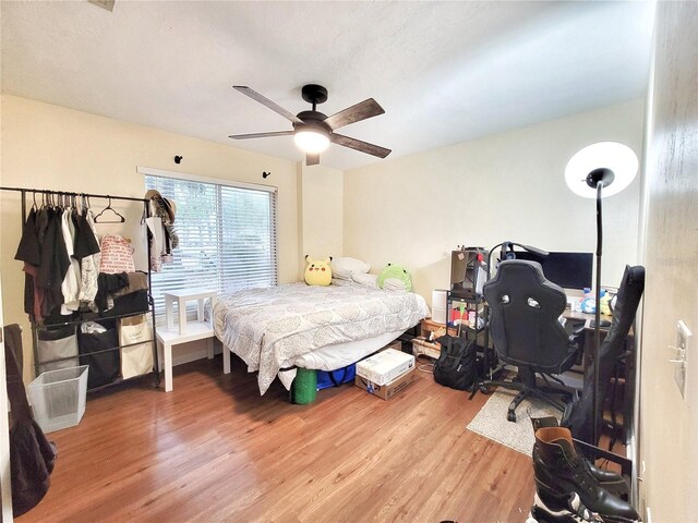 4000 SW 23rd St Unit 2-104, Gainesville, FL 32608 - bedroom with wood finished floors, a desk, and ceiling fan