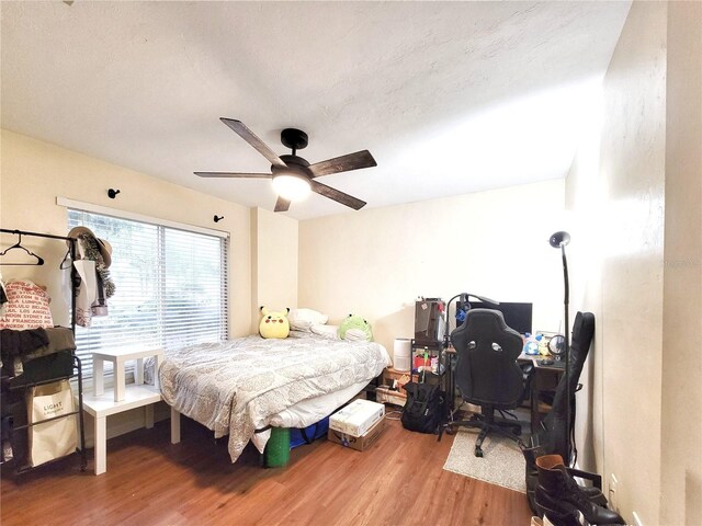 4000 SW 23rd St Unit 2-104, Gainesville, FL 32608 - bedroom featuring wood finished floors, a desk, and a ceiling fan