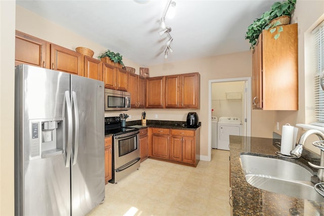 7547 SW 87th Ter, Gainesville, FL 32608 - kitchen with appliances with stainless steel finishes, washer and clothes dryer, brown cabinetry, and dark stone countertops