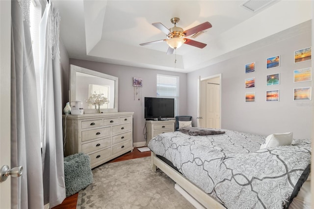 7547 SW 87th Ter, Gainesville, FL 32608 - bedroom with a tray ceiling, wood finished floors, and ceiling fan