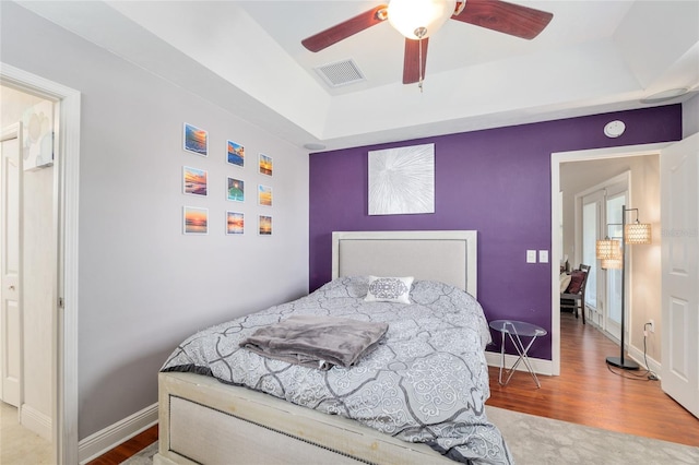 7547 SW 87th Ter, Gainesville, FL 32608 - bedroom featuring a tray ceiling, wood finished floors, and ceiling fan